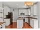 Bright kitchen with white cabinets, granite countertops, a stainless steel microwave, and hardwood floors at 6309 Crosshall Pl, Waxhaw, NC 28173