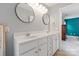 Bright bathroom features a double sink vanity with framed round mirrors and white cabinets at 6309 Crosshall Pl, Waxhaw, NC 28173