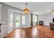 Open-concept living room with hardwood floors, a fireplace, natural light, and access to the patio at 6309 Crosshall Pl, Waxhaw, NC 28173