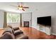 Bright living room featuring hardwood floors, a fireplace, and a large window at 6309 Crosshall Pl, Waxhaw, NC 28173
