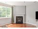 Comfortable living room featuring a cozy fireplace, a large window, and hardwood floors at 6309 Crosshall Pl, Waxhaw, NC 28173