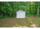 Backyard shot of the white storage shed in a wooded, private area ready for your lawn equipment and tools at 6309 Crosshall Pl, Waxhaw, NC 28173