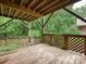 Wood back deck with lattice railing offers a serene view of the lush green backyard at 6647 Gaywind Dr, Charlotte, NC 28226
