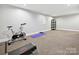 Spacious basement area featuring carpeted flooring and exercise equipment, offering a versatile space at 6647 Gaywind Dr, Charlotte, NC 28226