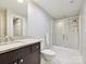 Bright bathroom featuring a granite-topped vanity, toilet, and a glass-enclosed shower for a clean design at 6647 Gaywind Dr, Charlotte, NC 28226