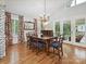 Elegant dining room featuring a chandelier, hardwood floors, and large windows with patterned curtains at 6647 Gaywind Dr, Charlotte, NC 28226