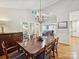 Formal dining room showcasing a chandelier, wainscoting, and access to the living room and outdoor patio at 6647 Gaywind Dr, Charlotte, NC 28226
