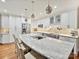 Gourmet kitchen with marble island, stainless steel appliances, white cabinetry, and tile backsplash at 6647 Gaywind Dr, Charlotte, NC 28226
