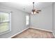 A neutral bedroom with a ceiling fan and a window allowing natural light into the room at 6705 E Douglas Park Dr, Huntersville, NC 28078