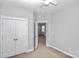 Neutral bedroom with a ceiling fan, closet, and open doorway to another room at 6705 E Douglas Park Dr, Huntersville, NC 28078