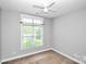 Neutral bedroom with a ceiling fan and a window allowing natural light into the room at 6705 E Douglas Park Dr, Huntersville, NC 28078