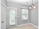 Bright dining area with natural light from windows and a door, complemented by a chandelier at 6705 E Douglas Park Dr, Huntersville, NC 28078