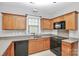 Efficient kitchen featuring wooden cabinets, black appliances, and ample counter space at 6705 E Douglas Park Dr, Huntersville, NC 28078
