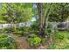 Lush backyard garden with mature trees, unique plants, and decorative elements, perfect for relaxation at 6827 Dunton St, Huntersville, NC 28078