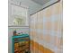 Bathroom with bright yellow shower curtain, colorful cabinet, and natural light from window at 6827 Dunton St, Huntersville, NC 28078