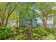 Exterior view of the home with a lush backyard, patio, and a charming garden path leading to the house at 6827 Dunton St, Huntersville, NC 28078