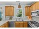 Eat-in kitchen with wooden cabinets, stainless appliances and a double sink below a window at 6827 Dunton St, Huntersville, NC 28078