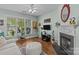 Comfortable living room with fireplace, hardwood floors, and a large window with natural light at 6827 Dunton St, Huntersville, NC 28078