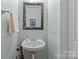 Charming powder room with a decorative mirror and pedestal sink at 6827 Dunton St, Huntersville, NC 28078
