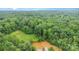 Scenic aerial view of a densely wooded property with a small pond and some clearing at 6934 Lockhart Rd, Sharon, SC 29742