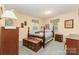 Cozy bedroom featuring a four-poster bed, classic wood furniture, and soft blue carpet at 6934 Lockhart Rd, Sharon, SC 29742