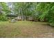 Quaint home exterior featuring a covered parking area surrounded by lush greenery and mature trees at 6934 Lockhart Rd, Sharon, SC 29742