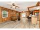 Spacious living room with wood-paneled walls and ceiling fans, seamlessly connecting to the kitchen at 6934 Lockhart Rd, Sharon, SC 29742