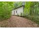 Exterior shot of a long outbuilding with a simple door, nestled among trees and foliage at 6934 Lockhart Rd, Sharon, SC 29742