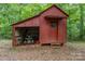 A small red storage shed with an open bay for tools and equipment, adding storage space at 6934 Lockhart Rd, Sharon, SC 29742