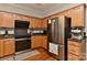 Modern kitchen featuring stainless steel appliances, wooden cabinets, and efficient design at 705 Moss Creek Dr, Matthews, NC 28105