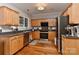 Well-lit kitchen featuring wood cabinetry, stainless steel appliances, and a functional layout at 705 Moss Creek Dr, Matthews, NC 28105