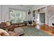 Comfortable living room with hardwood floors, large windows, and views to the front yard and foyer at 705 Moss Creek Dr, Matthews, NC 28105