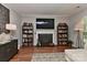 Cozy living room featuring a fireplace, built-in bookshelves, and hardwood floors at 705 Moss Creek Dr, Matthews, NC 28105