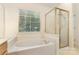 Bathroom showcasing a soaking tub and a separate glass-enclosed shower at 7226 Reedy Creek Rd, Charlotte, NC 28215