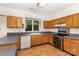 Functional kitchen featuring oak cabinets, laminated flooring, stainless steel appliances, and ample countertop space at 7226 Reedy Creek Rd, Charlotte, NC 28215