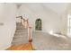 Spacious living room featuring a staircase, a large window, and neutral carpeting at 7226 Reedy Creek Rd, Charlotte, NC 28215