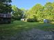 Expansive backyard featuring lush greenery and multiple storage sheds at 850 Meadowbend Dr, York, SC 29745