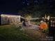 Backyard features a fire pit, chairs, string lights, and an outdoor living space at night at 850 Meadowbend Dr, York, SC 29745