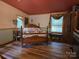 Inviting bedroom featuring wood floors, a red ceiling, and natural light from two windows at 850 Meadowbend Dr, York, SC 29745