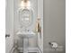 Stylish powder room featuring a pedestal sink, chrome fixtures and towel racks, and neutral walls at 9750 Briarwick Ln, Charlotte, NC 28277