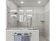 Bright bathroom featuring a glass-enclosed shower with marble surround, rainfall shower head, and tiled walls at 9750 Briarwick Ln, Charlotte, NC 28277