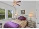 Elegant bedroom featuring a decorative ceiling fan and plush bedding, illuminated by bedside lamps near a window at 9750 Briarwick Ln, Charlotte, NC 28277