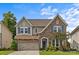Charming two-story home boasts stone accents, blue shutters, and manicured landscaping at 9750 Briarwick Ln, Charlotte, NC 28277