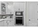 Bright kitchen featuring stainless steel KitchenAid appliances including a microwave and oven combo and white cabinets at 9750 Briarwick Ln, Charlotte, NC 28277