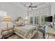 Luxurious main bedroom featuring a tray ceiling, a sitting area, a ceiling fan, and many windows at 9750 Briarwick Ln, Charlotte, NC 28277