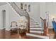 Elegant staircase with hardwood steps and iron railings, complemented by decorative chairs and lighting at 9750 Briarwick Ln, Charlotte, NC 28277