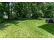 Lush backyard with mature trees, a neatly manicured lawn, and an outdoor grill at 10322 Stoneykirk Ln, Charlotte, NC 28269