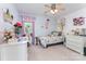 Bright bedroom with a whimsical design, featuring a ceiling fan, desk, and ample storage at 10322 Stoneykirk Ln, Charlotte, NC 28269