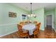 Bright dining room with hardwood floors, a table for six, and green painted walls at 10322 Stoneykirk Ln, Charlotte, NC 28269