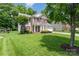 Inviting two-story home with brick facade, red shutters, and lush green lawn at 10322 Stoneykirk Ln, Charlotte, NC 28269